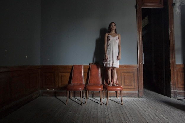 Woman standing on chair at home
