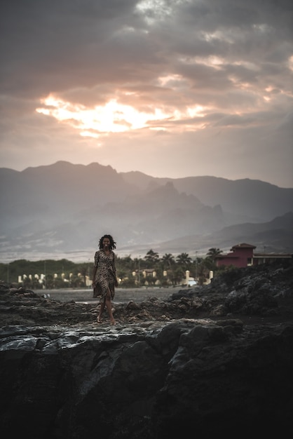 Woman standing in a cliff seashore with the ocean below