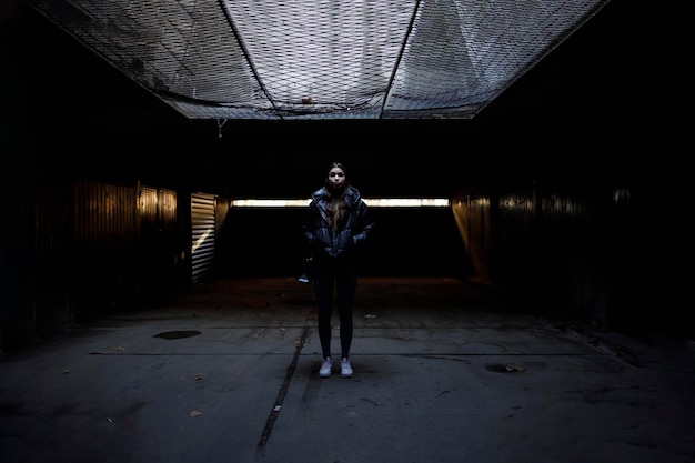 A woman standing in the dark shelter waiting during the air raid