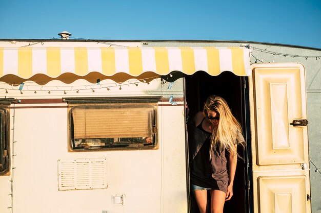 Photo woman standing at entrance of motor home against sky