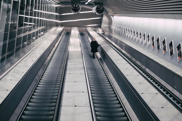 Woman standing on escalator