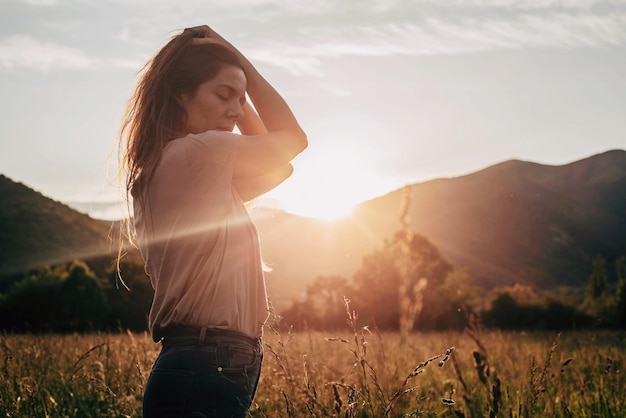 woman standing on field against sky during sunset