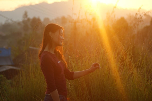 woman standing on field against sky during sunset