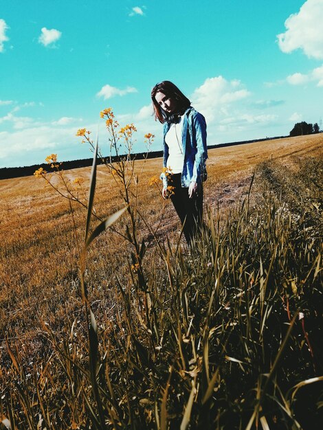 Woman standing on field against sky