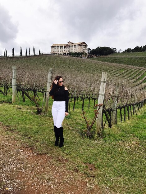 Foto donna in piedi sul campo contro il cielo