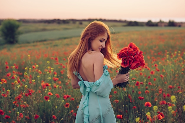 Woman standing in flowering poppy field