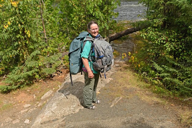 Foto donna in piedi sul sentiero nella foresta