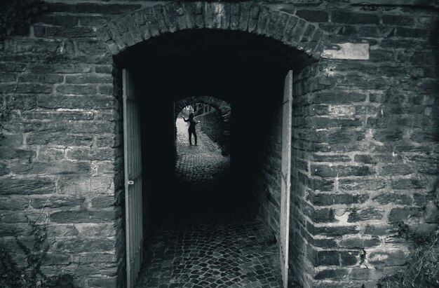 Photo woman standing on footpath seen through archway