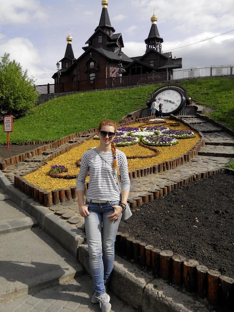 A woman standing in front of a clock with a clock on it