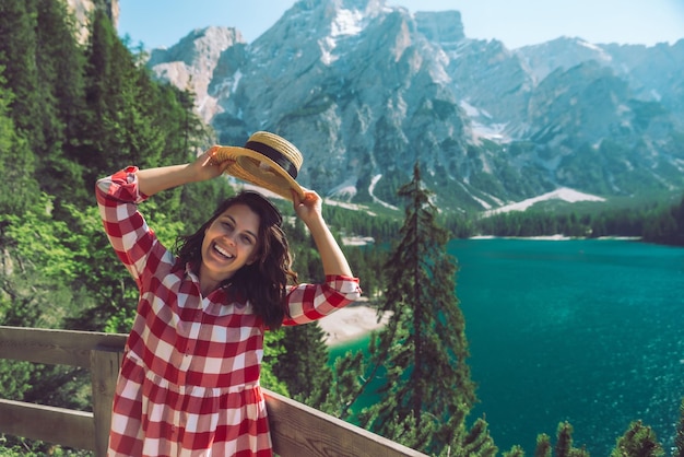 山の湖の前に立っている女性夏の旅行のコンセプト