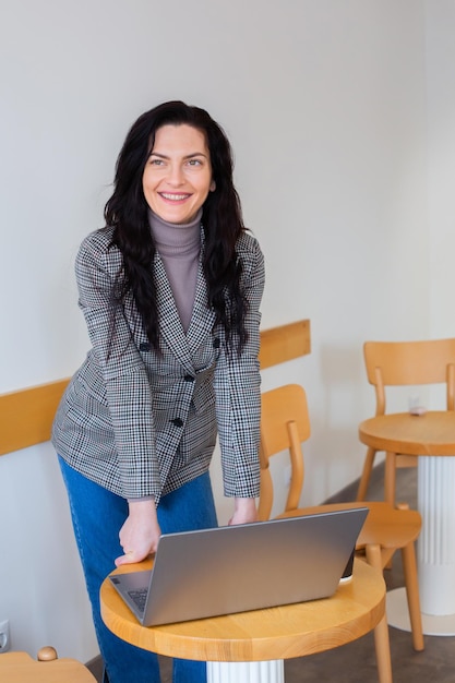 A woman standing in front of a laptop