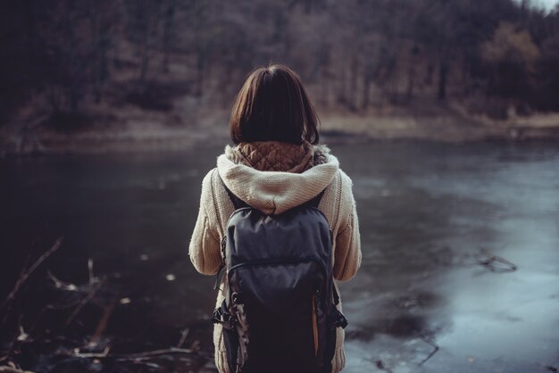 山の湖の前に立っている女性