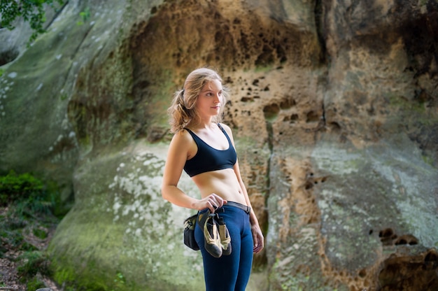 Woman standing in front of a stone rock wall outdoor