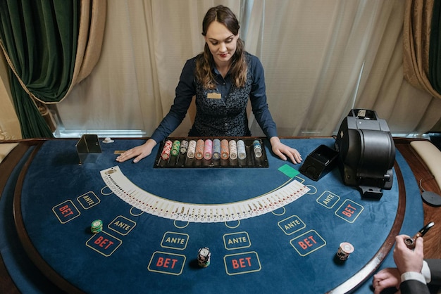 Photo a woman standing behind a gaming table stock photo