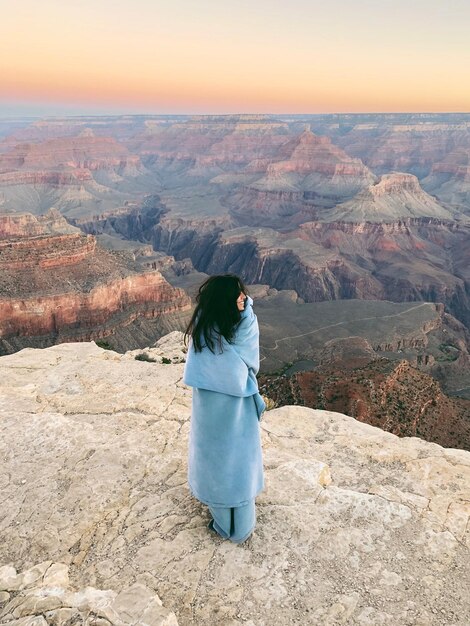 Foto donna in piedi al grand canyon national park durante l'alba