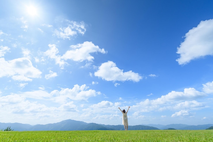 Photo 雲の空に逆らって草原に立っている女性