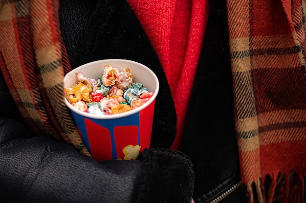 Woman standing and hold bucket full of popcorn