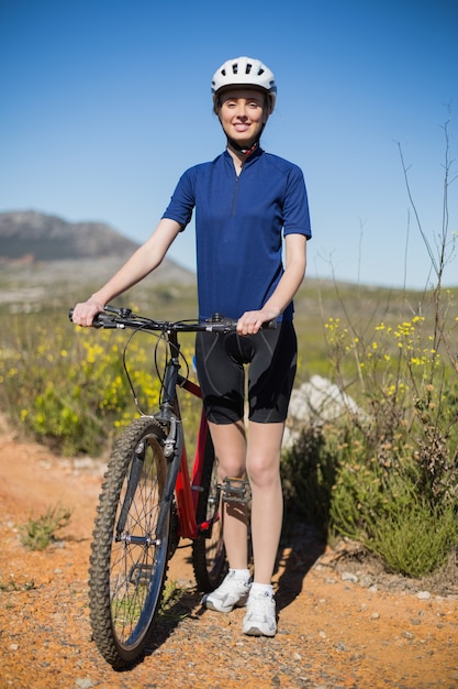 Woman standing and holding bike