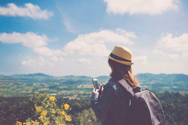 Foto donna in piedi e tenendo smartphone