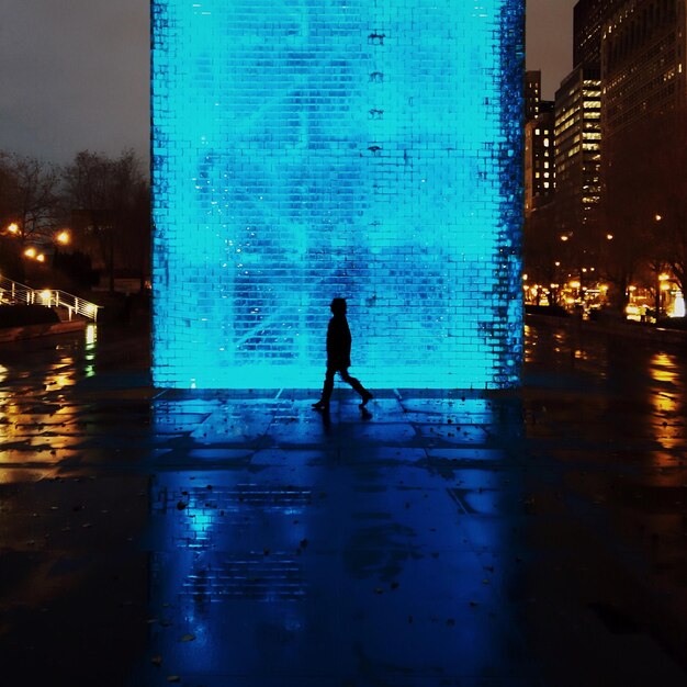 Photo woman standing in illuminated city at night