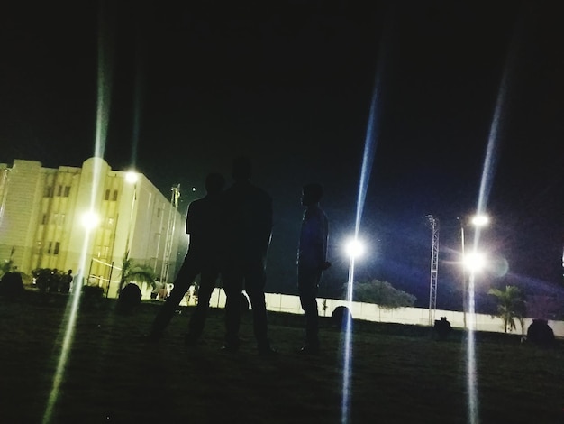 Photo woman standing on illuminated street light at night