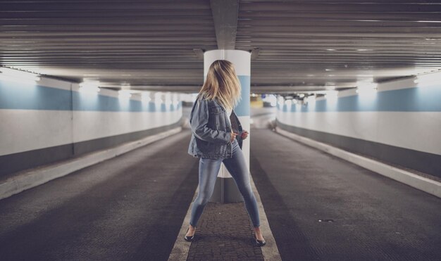 写真 照らされた地下鉄駅に立っている女性