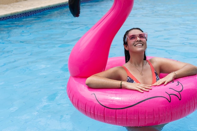 Woman standing on an inflatable ring floating in the pool