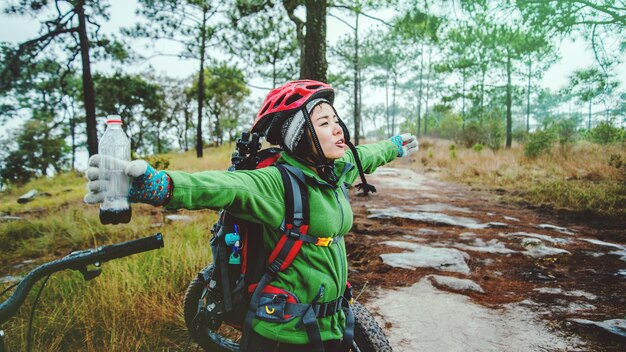 Photo woman standing on land by trees in forest