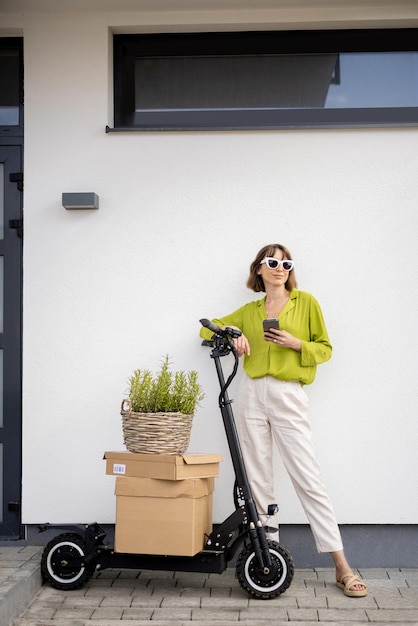 Woman standing near scooter with parcels and flowerpot