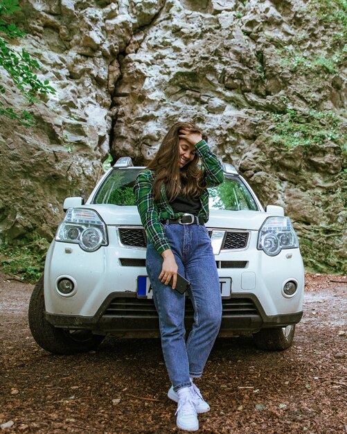 森の白い suv 車の近くに立っている女性