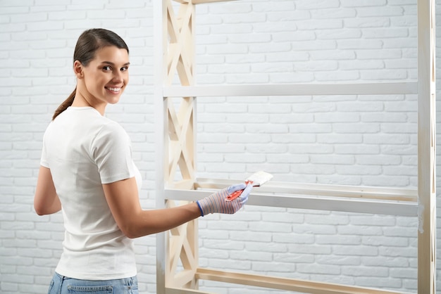 Woman standing near wooden rack with brush
