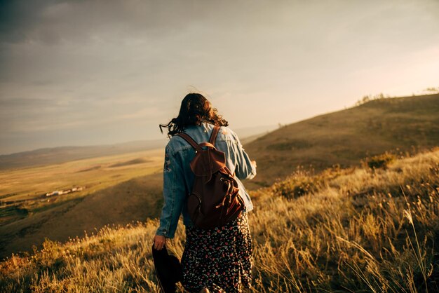 写真 夕暮れの空に照らされた畑に立っている女性