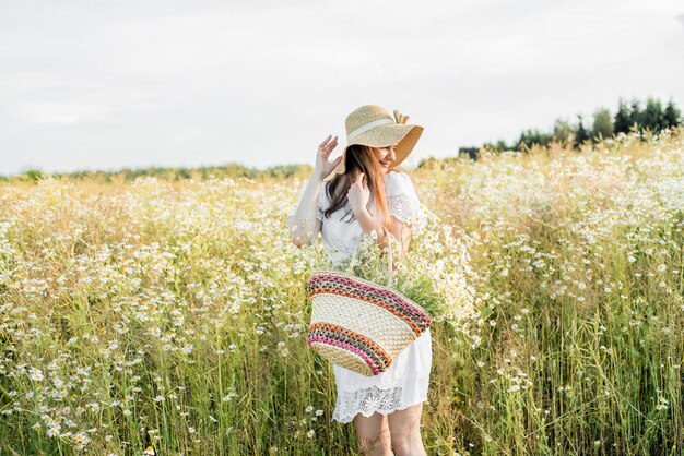 写真 空に向かって花の畑に立っている女性