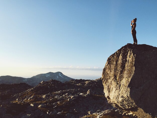 Фото Женщина, стоящая на скале на небе