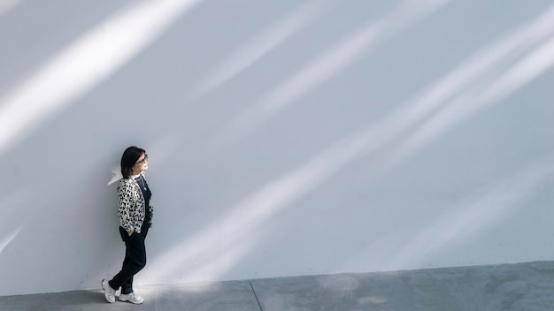 写真 晴れた壁に立っている女性