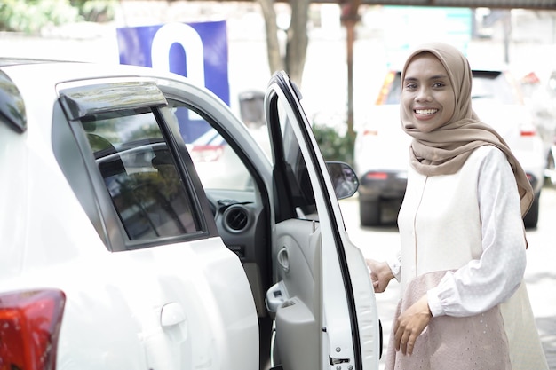 Woman standing and opening the door in her car outdoors