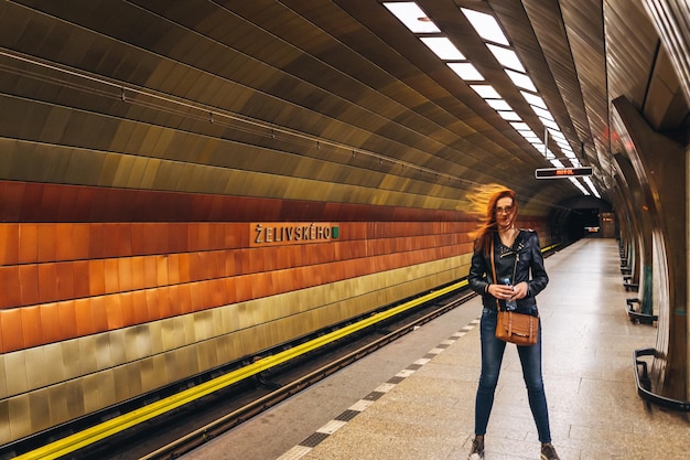 Foto donna in piedi sulla piattaforma della stazione ferroviaria