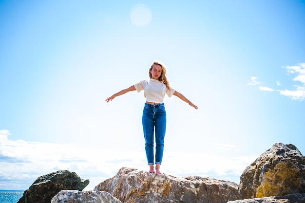 Foto donna in piedi su una roccia contro il cielo blu