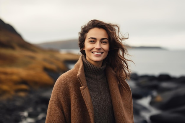 a woman standing on a rocky beach next to a body of water