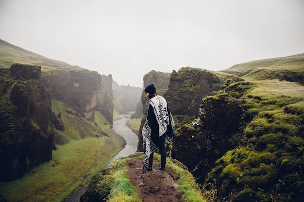 Woman standing at scenic mountains against sky