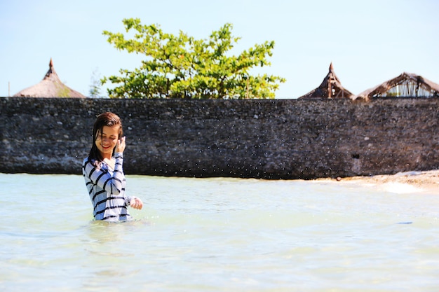 Woman standing in sea against sky