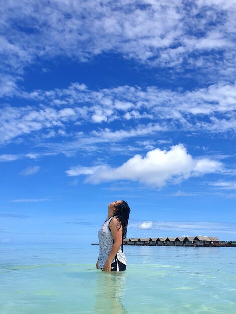 Foto donna in piedi in mare contro il cielo