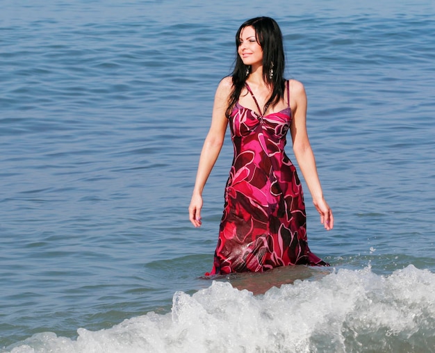 Woman standing in sea waves