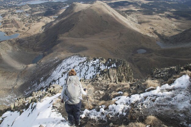 Foto donna in piedi su una montagna coperta di neve