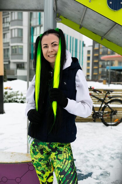 Woman standing in snow with neon green hair