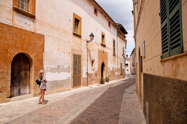 Woman standing on street amidst buildings