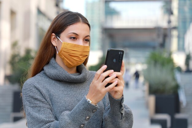 Woman standing on street in protective mask and messaging