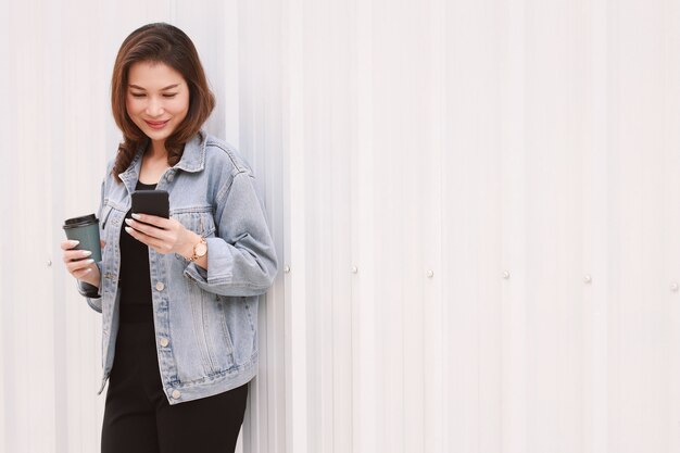 Woman standing and using smartphone.