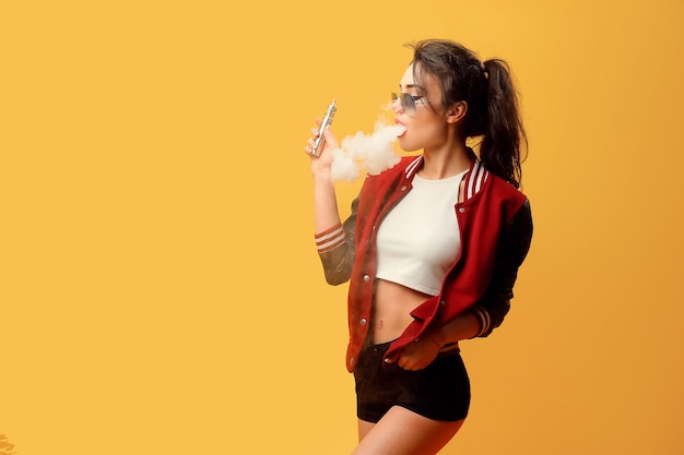 Woman standing and vaping in studio