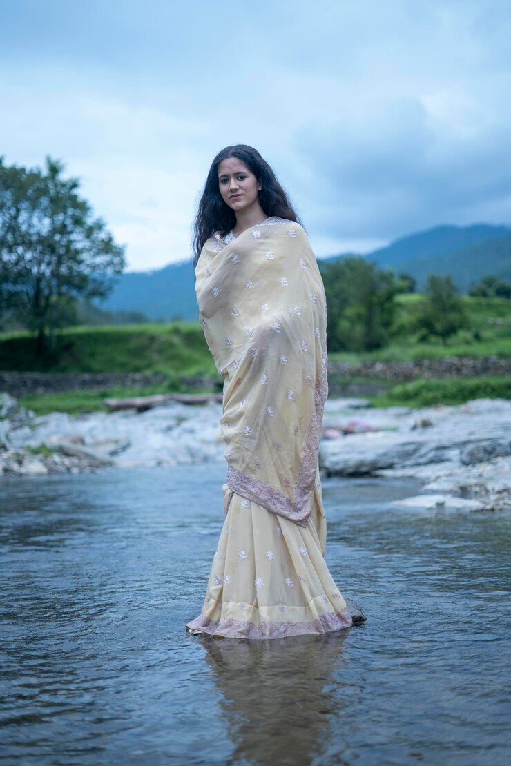 फोटो आकाश के विपरीत पानी में खड़ी महिला